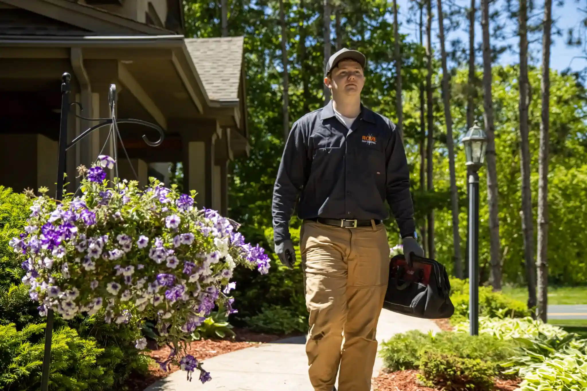 Young pest control worker walking on a sidewalk