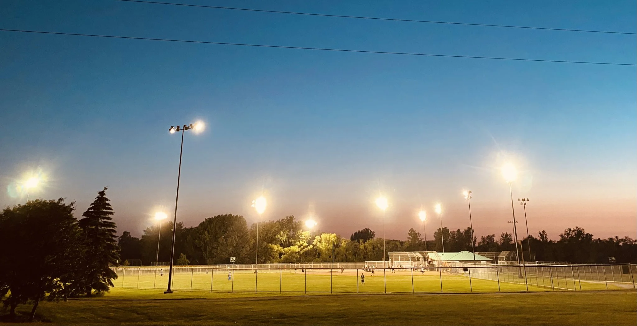 Lights illuminating a baseball stadium at night