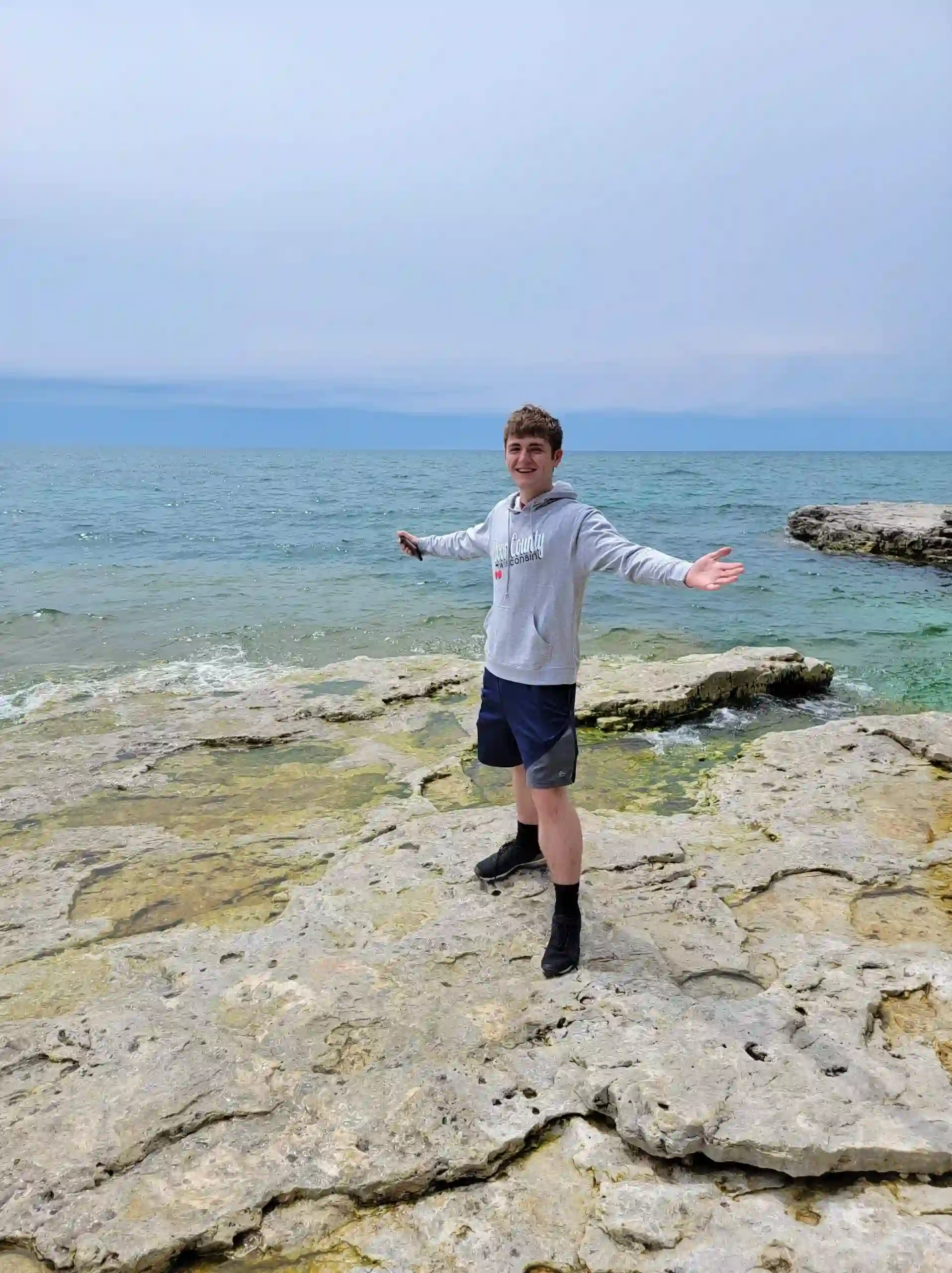 Boy poses in front of ocean